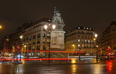 Fototapeta na wymiar Place de Clichy at rainy night , Paris. Bronze statue of Marechal Moncey at the centre of the square. Crossing four districts of the city at one point.
