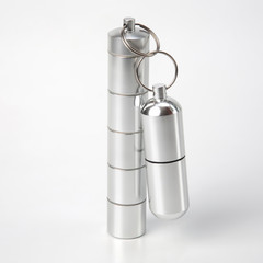 sealed aluminum containers for small items and medical pills on a white background