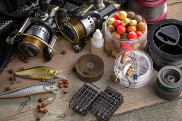 Fishing rods and spinnings in the composition with accessories for fishing on the old background on the table