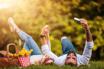 Happy couple enjoying picnic in summer park