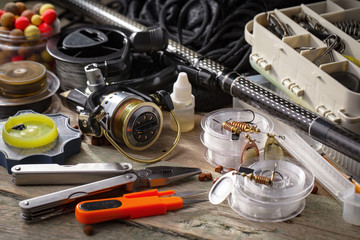 Fishing rods and spinnings in the composition with accessories for fishing on the old background on...