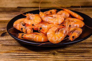 Plate with raw shrimps on a wooden table