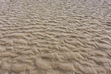 sandy beach close up. traces and ripples left by the ocean at low tide. plage de sable en gros...