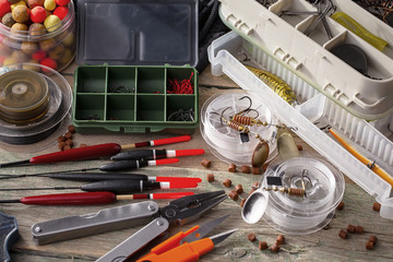 Fishing rods and spinnings in the composition with accessories for fishing on the old background on...