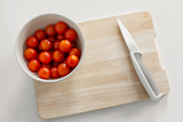 A bowl of cherry tomatoes on a cutting board. Cooking healthy and tasty food