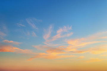 Golden sunset clouds in a clear blue sky. Scenic dusk skyscape. Twilight paradise sky. Calm heaven background.