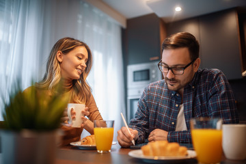 Happy couple having breakfast at home