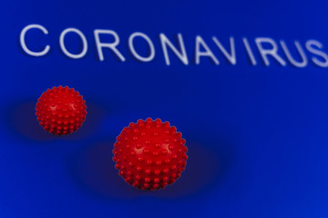 the word coronavirus laid with white letters on classic blue background. Red ball as a symbol of coronavirus. The news of the epidemic in China