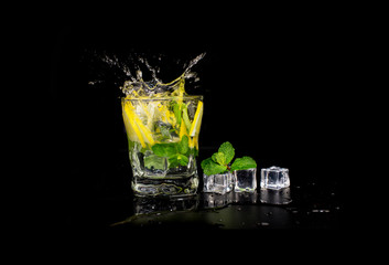  mojito cocktail drink with mint and lemon lime in a glass splash splashing out of a glass with ice cubes, drops and splashes on a black background