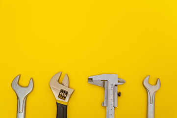 Necessary set of tools for plumbers on yellow background