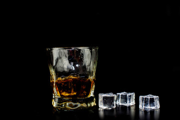  alcohol drink whiskey with ice cubes on a black background