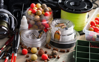 Fishing rods and spinnings in the composition with accessories for fishing on the old background on the table