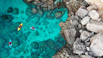 view of a drone from a drone people are kayaking in the sea near the mountains in a cave with turquoise water on the island of Cyprus Ayia Napa