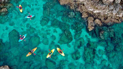 view of a drone from a drone people are kayaking in the sea near the mountains in a cave with turquoise water on the island of Cyprus Ayia Napa