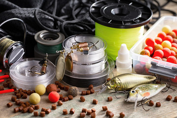 Fishing rods and spinnings in the composition with accessories for fishing on the old background on the table