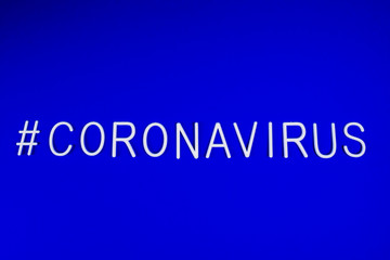 the word coronavirus laid with white letters on classic blue background. News on social networks. Hashtag. Flat lay, copyspace