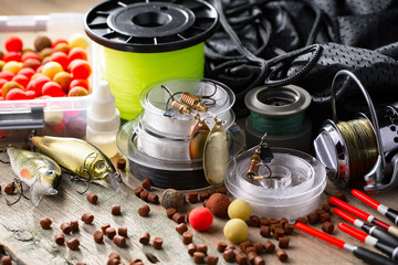 Fishing rods and spinnings in the composition with accessories for fishing on the old background on the table