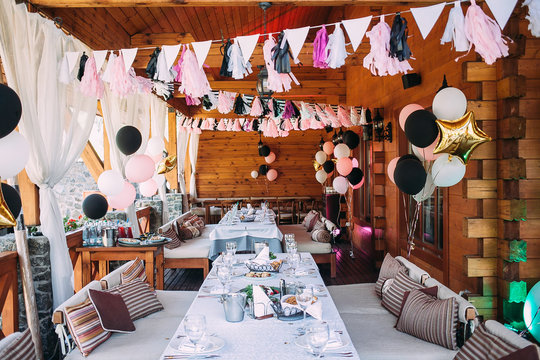 Decorated with balloons and ribbons birthday terrace. Pink and black decoration. Birthday party