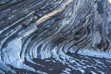 Fototapeta premium Details of curves of the Geopark in Sakoneta in Deba at low tide. Basque Country