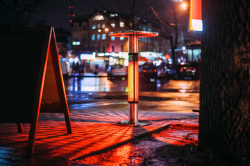 Street heater with a beautiful red light and bokeh in the form of a city street