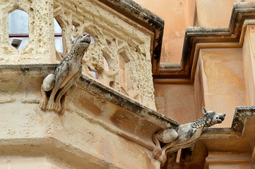 Dog-like gargoyles outside a neo-Gothic building in Mdina, Malta