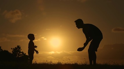 Father and his little boy paying together throwing American football in the park.  - Powered by Adobe