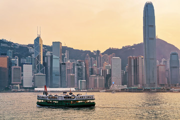 Fototapeta premium Star ferry at Victoria Harbor of HK at sundown. View from Kowloon on Hong Kong Island.
