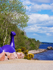 Nessie, Loch ness monster figure in Loch Ness in Scotland. Loch Ness is a city in the Highlands in...