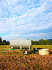Obraz premium Water trough for drinking for cow cattle at the field, Franche Comte, France.