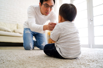 Fototapeta premium Young father taking care of little baby boy son child at home. Family supporting time