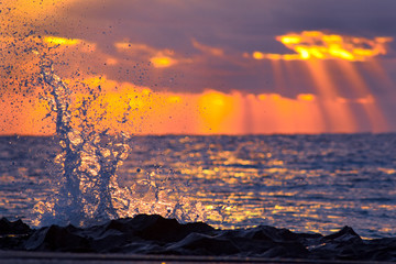 surf on rocks at sunrise