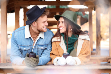 Happy young couple on Christmas fair outdoors