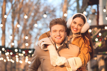 Happy young couple walking outdoors on winter day