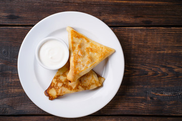 Crepes, pancakes, blinis with sour cream. Tasty morning meals, breakfast menu idea