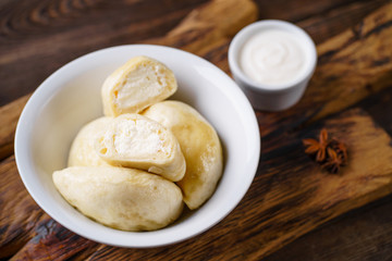 Vareniki dumplings, pierogi. Traditional Ukrainian food. Cooked and served with sour cream vareniki, pyrohy or dumplings, filled with cottage cheese