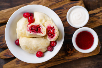 Dumplings with cherries. Vareniki dumplings, pierogi. Traditional Ukrainian food. Cooked and served with sour cream and berry sauce vareniki, pyrohy or dumplings