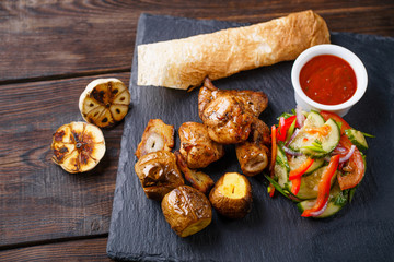 Spicy hot grilled pork meat with baked potatoes and vegetable salad, summer BBQ, traditional american cuisine, grill and barbeque, meat restaurant menu