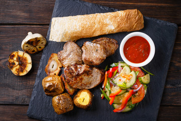 Spicy hot grilled beef with baked potatoes and vegetable salad, summer BBQ, traditional american cuisine, grill and barbeque, meat restaurant menu