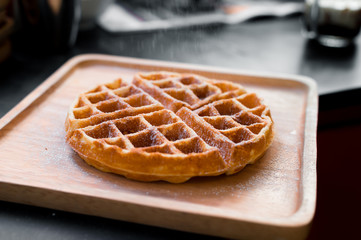 waffles with butter on wooden plate