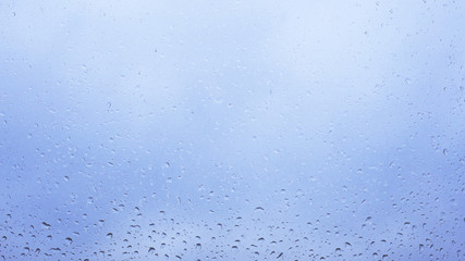 water droplets on window and cloudy sky outside. bad weather in rainy season. overcast sky and many clouds cover the sky.