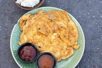 Traditional Thai food ,Omelette or Scrambled eggs made from eggs and minced pork with chili sauce and ketchup on the table.Minced pork in omelette.
