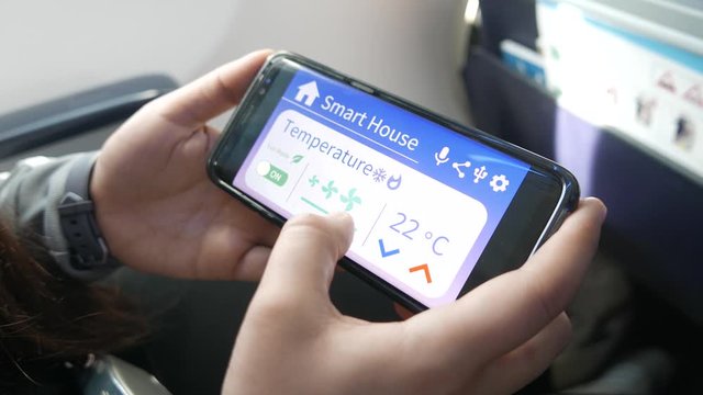 Changing smart home settings while traveling by plane with a mobile phone device.