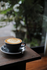 cappuccino or Latte art coffee made from milk on the wood table in coffee shop