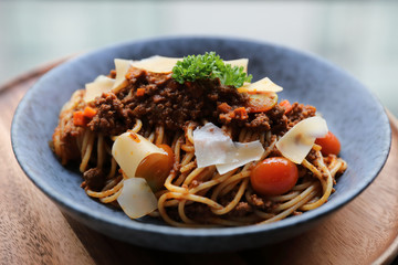 spaghetti Bolognese with minced beef and tomato sauce garnished with parmesan cheese and basil , Italian food