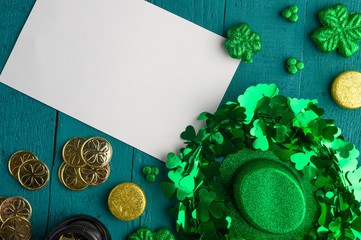 Traditional Irish holiday St. Patrick's Day, March 17th celebration, with accessories for celebrating on a green wooden background. With a card for congratulation