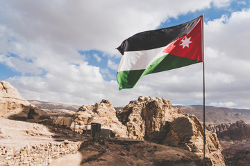 The flag of Jordan blowing in the wind in Petra, Jordan. Three-color flag of Jordan on the...
