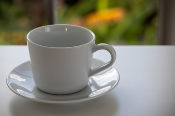 Close up A white coffee cup placed by the window