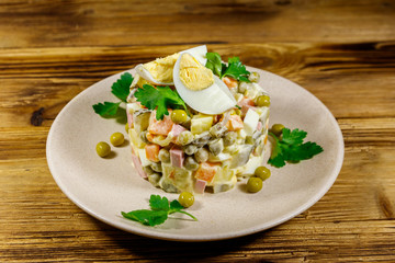 Traditional Russian festive salad Olivier on wooden table