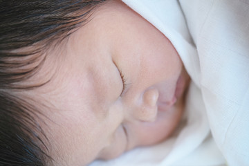 Closeup a baby sleeping comfortably on the bed