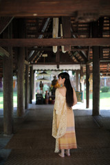 Obraz premium Portrait of Thai female with traditional Thai dress with temple background